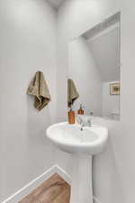 Bathroom with lofted ceiling, sink, and wood-type flooring