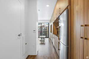 Kitchen with hardwood / wood-style floors and stainless steel refrigerator