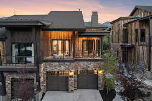 View of front of property featuring a balcony and a garage