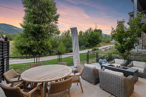 Patio terrace at dusk featuring a balcony, a mountain view, and outdoor lounge area