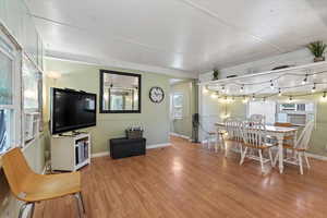 Living room with cooling unit, wood-type flooring, and plenty of natural light