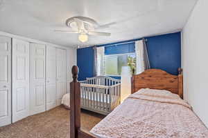 Bedroom with carpet, ceiling fan, and a closet