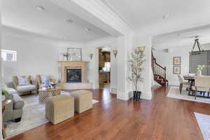 Living room with crown molding, dark hardwood / wood-style floors, and a premium fireplace