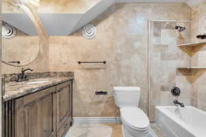 Upstairs Full bathroom featuring tile patterned floors, tiled shower / bath, vanity, and toilet