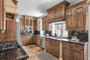 Kitchen featuring a wealth of natural light, backsplash, and appliances with stainless steel finishes