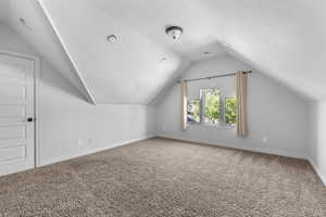 Upstairs bedroom with carpet flooring, lofted ceiling and walk in closet