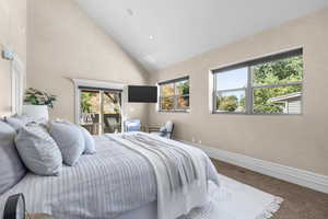 Owner's Suite bedroom with high vaulted ceiling and access to outside deck with hot tub