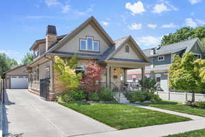 Craftsman-style home with a front yard, porch and oversized two car garage