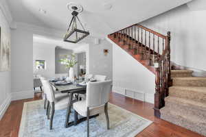 Formal Dining area featuring a notable chandelier, crown molding, and hardwood / wood-style floors