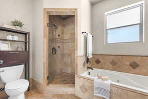 Owner's Bathroom featuring walk in shower, soaking tub and tile patterned floors