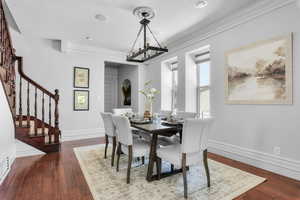 Formal Dining space featuring a notable chandelier, hardwood / wood-style floors, and crown molding