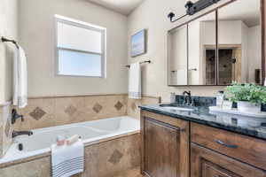 Owner's Bathroom with shower with separate soaking bathtub, vanity and toilet