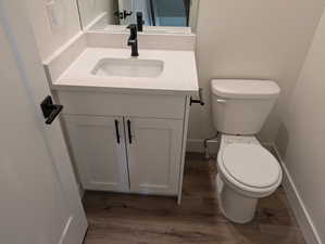 Bathroom featuring hardwood / wood-style floors, toilet, and vanity