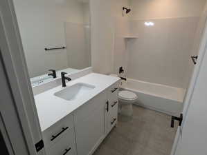 Full bathroom featuring bathtub / shower combination, vanity, toilet, and tile patterned floors