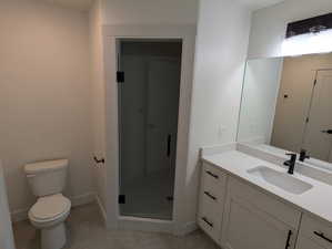 Bathroom with vanity, toilet, tile patterned floors, and a shower with shower door