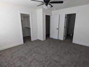 Unfurnished bedroom with carpet, connected bathroom, a walk in closet, and ceiling fan