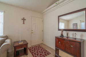 Carpeted entrance foyer featuring vaulted ceiling