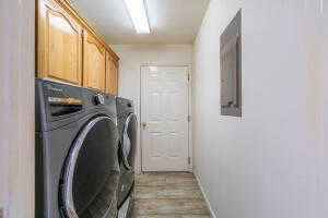 Laundry area featuring light wood-type flooring, cabinets, and washer and clothes dryer