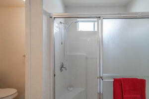 Bathroom with toilet and a shower with door