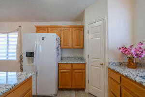 Kitchen featuring light stone countertops and white fridge with ice dispenser