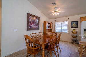 Dining space with vaulted ceiling and wood-type flooring