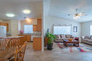 Living room with light wood-type flooring, lofted ceiling, and ceiling fan