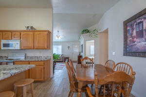 Dining room with light hardwood / wood-style flooring and vaulted ceiling