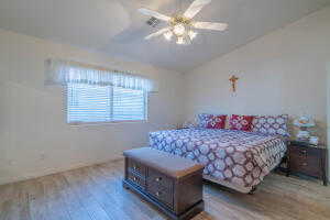 Bedroom with vaulted ceiling, hardwood / wood-style floors, and ceiling fan