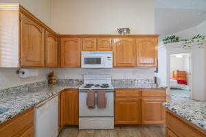 Kitchen with white appliances and light stone counters