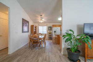 Dining room featuring wood-type flooring, vaulted ceiling, and ceiling fan