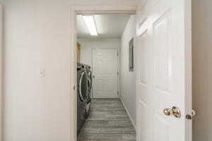 Clothes washing area featuring hardwood / wood-style floors, cabinets, and washing machine and dryer