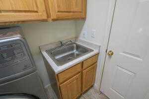 Clothes washing area featuring cabinets and sink