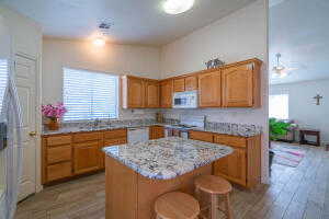 Kitchen featuring a kitchen island, a breakfast bar, light hardwood / wood-style flooring, and white appliances