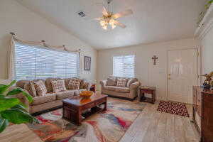 Living room with lofted ceiling, hardwood / wood-style floors, and ceiling fan