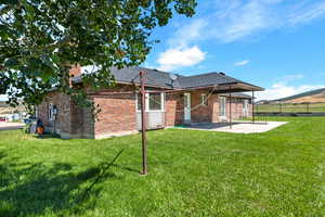 Rear view of house with a yard and a patio area