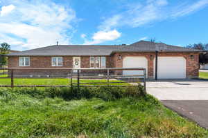 Ranch-style house featuring a garage and a front lawn