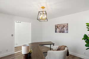 Interior space with dark wood-type flooring and a chandelier