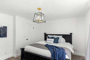 Bedroom with hardwood / wood-style flooring and a notable chandelier