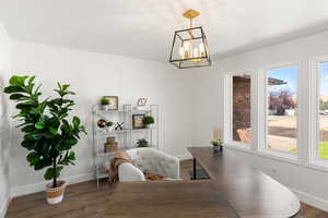 Dining area featuring a notable chandelier and dark hardwood / wood-style flooring