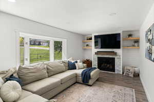 Living room featuring light hardwood / wood-style flooring and a stone fireplace