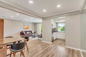 Dining space with light laminate flooring and crown molding