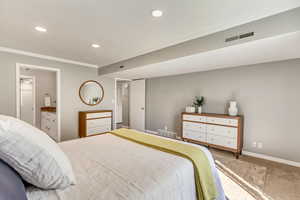 Bedroom featuring ornamental molding, connected bathroom, and carpet floors