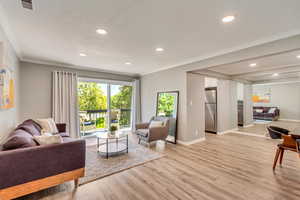 Living room featuring crown molding and light hardwood / wood-style flooring