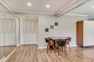 Dining space with ornamental molding and laminate flooring