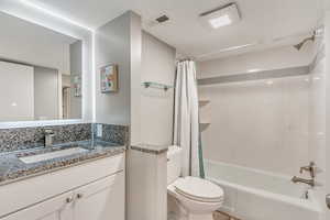 Full bathroom with shower / bath combination with curtain, toilet, and vanity