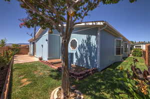 View of side of home with a yard and a patio area