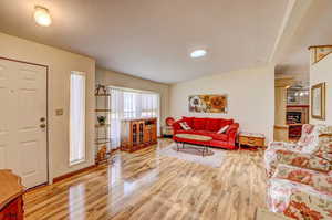 Living room featuring a brick fireplace and light hardwood / wood-style floors