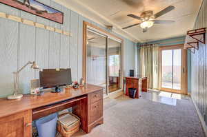 Office with a textured ceiling and ceiling fan