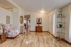 Foyer featuring vaulted ceiling and light hardwood / wood-style flooring