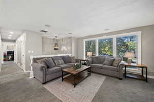 Carpeted living room featuring a textured ceiling